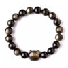 Close up of a black gold sheen obsidian bracelet with a carved cat head charm