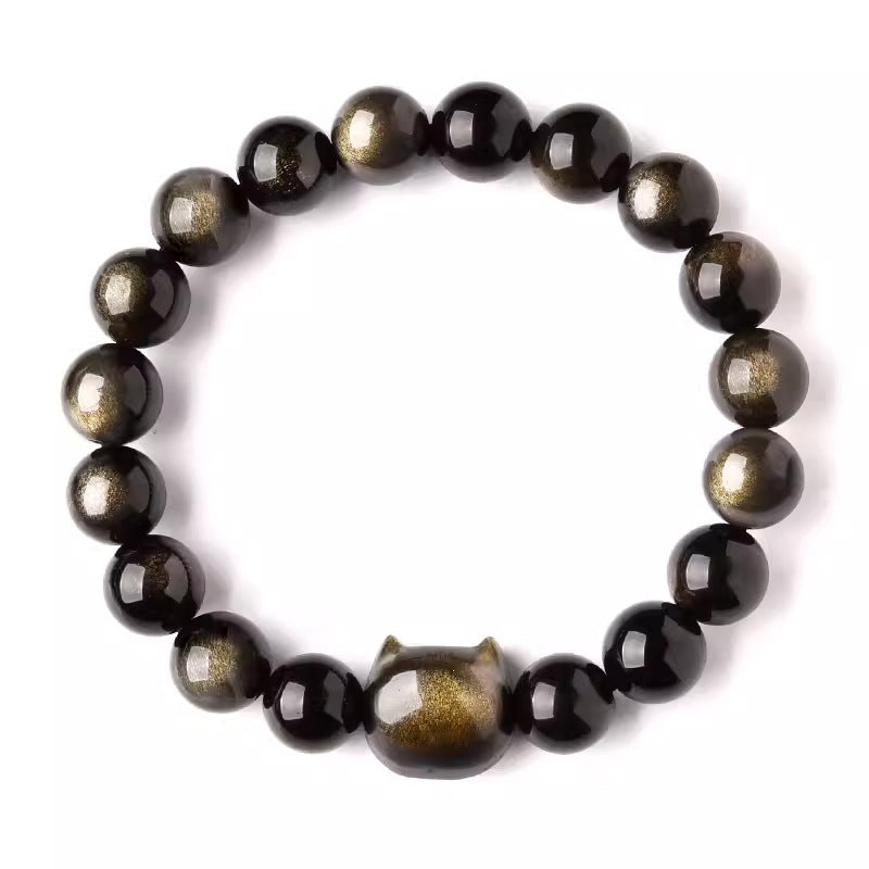 Close up of a black gold sheen obsidian bracelet with a carved cat head charm