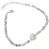 Close up of a silver tone bracelet with irregular beads and one pearl on a wrist