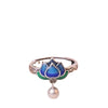 Close up of a blue lotus flower enamel ring on a finger