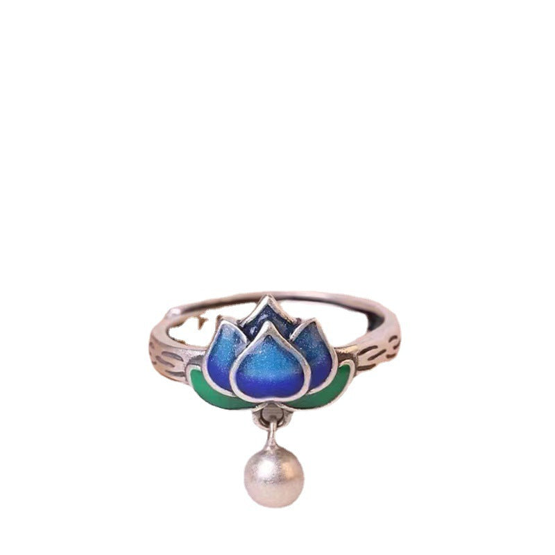 Close up of a blue lotus flower enamel ring on a finger