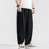 Man wearing black loose-fit linen harem pants with elastic waist