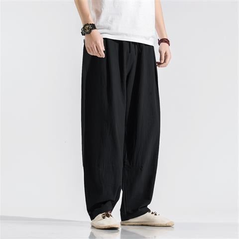 Man wearing black loose-fit linen harem pants with elastic waist