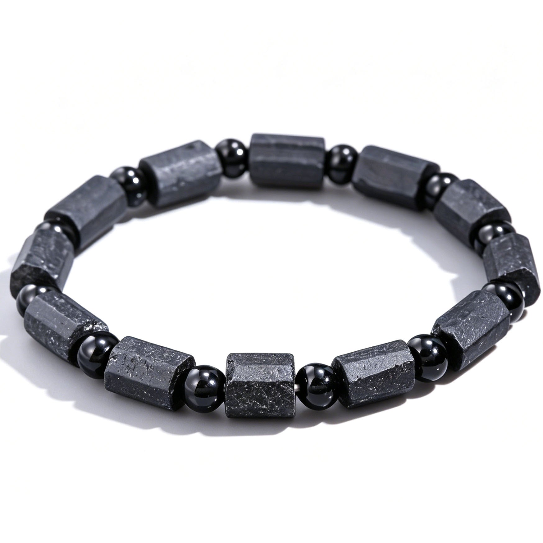 Close up of a black tourmaline bracelet with rectangular stones on a white background