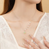 Close up of silver necklace with pearls and green stone pendant on model