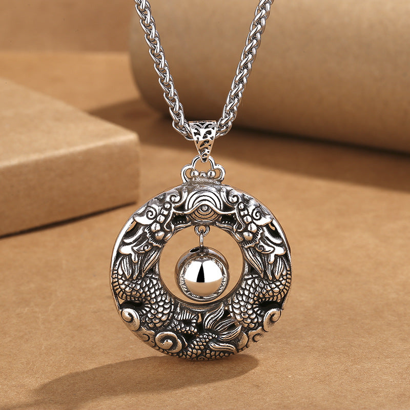 Close up of a round copper pendant with two dragons chasing a pearl