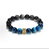 Blue and black natural stone bead bracelet with a gold charm