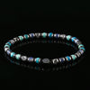 A beaded bracelet with blue, teal, and grey stones on a black background