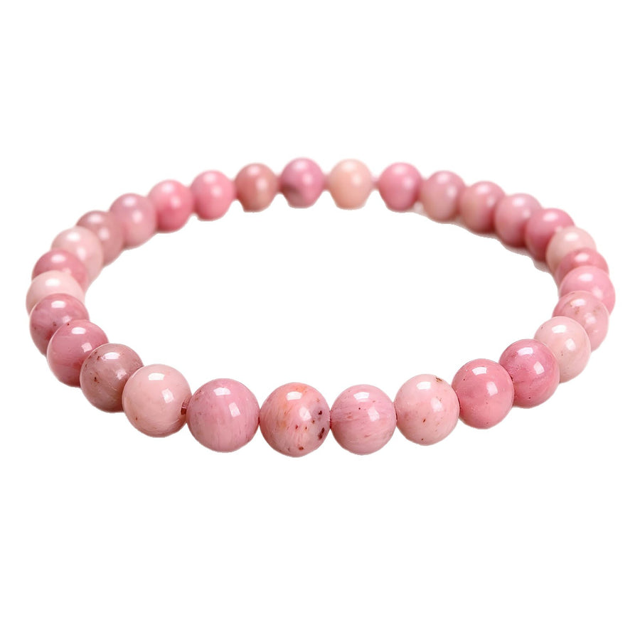 Close-up of a pink rhodochrosite beaded stretch bracelet on a white background