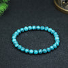 Close up view of a blue turquoise beaded bracelet held in hand showing the stone texture