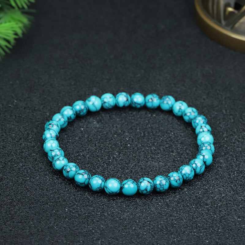 Close up view of a blue turquoise beaded bracelet held in hand showing the stone texture