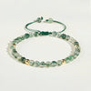 Green moss agate beaded bracelet with gold accents on white background