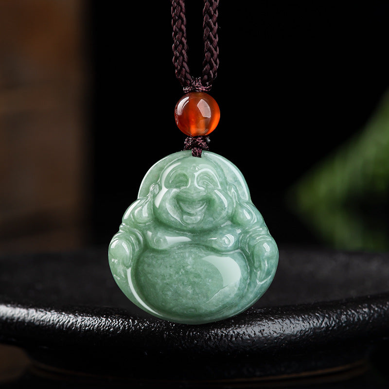 Close up of a carved green jade laughing Buddha pendant on a brown cord