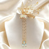 Gold-tone metal hair clip with butterfly motif and hanging tassels on a mannequin head