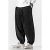 Black corduroy harem pants on a model showing the loose fit and drawstring waist