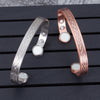 Two open cuff bracelets with magnetic clasps and loop patterns in copper and silver tones