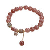 Pinkish-red beaded bracelet with gold-tone accents and a flower charm
