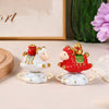 Two rotating sheep ornaments, one white and one red, sitting on a desk.