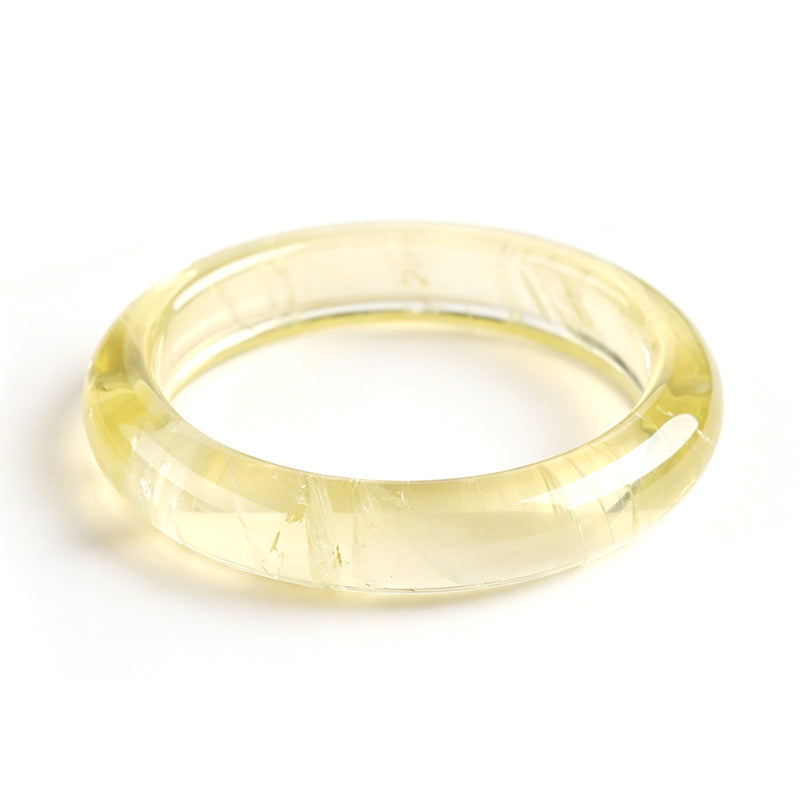 Two yellow natural quartz crystal bangles on a black background