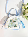 Light blue and white embroidered drawstring bag with a peony flower motif and blue tassel