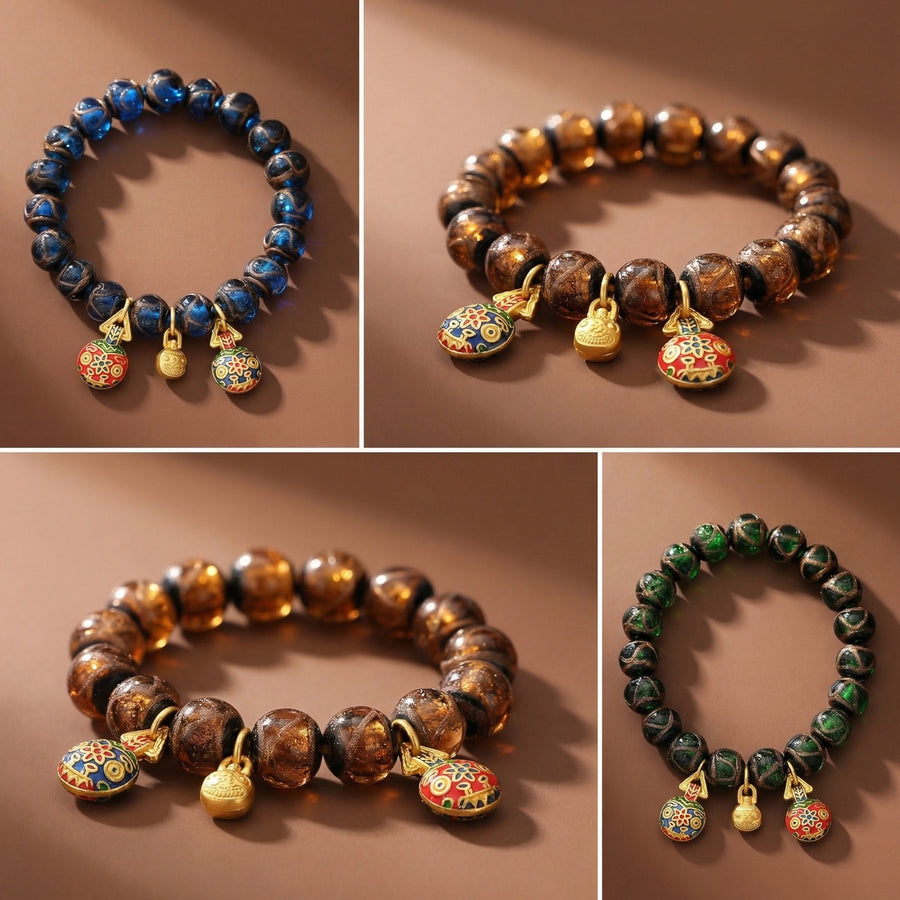 Close up of a blue Liuli glass bead bracelet with gold tone charms on a brown background