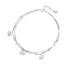 Close up of a silver tone double layer anklet with ginkgo leaf charms on an ankle