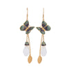 Gold tone butterfly earrings with white jade-like drop on a display stand