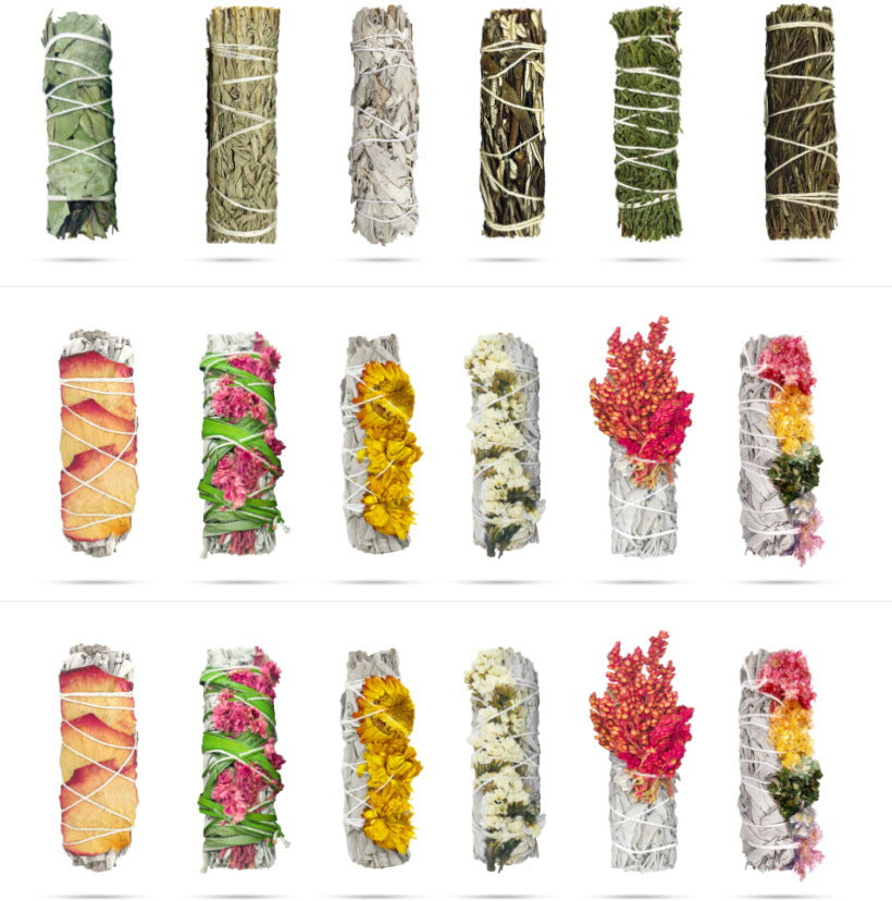 Assortment of hand-tied white sage smudge sticks with various dried flowers and herbs