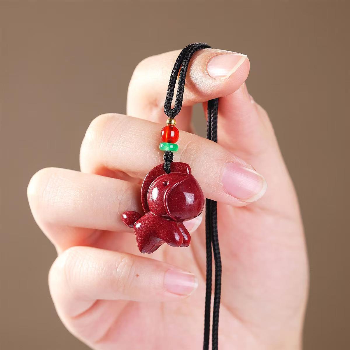 Red cinnabar horse pendant on a black cord