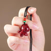 Red cinnabar horse pendant on a black cord