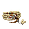 Close up of a wrapped 108 bead bodhi seed mala bracelet with red and dzi beads on a wooden tray