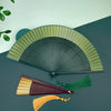 Open gradient handheld bamboo folding fan with green and yellow tones and a matching tassel