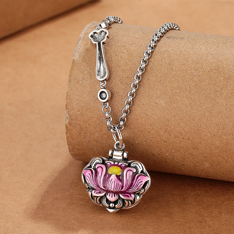 Close up view of a pink lotus flower pendant on a silver tone chain
