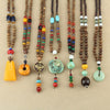 A collection of long wood bead necklaces with various alloy pendants and colorful accent beads.