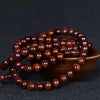 Close up of a dark wood bead bracelet on a black background