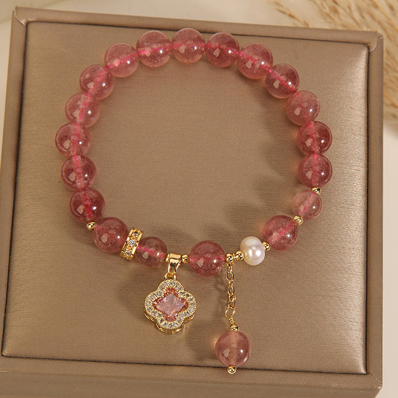 Pink strawberry quartz beaded bracelet with a gold-tone four-leaf clover charm and white pearl