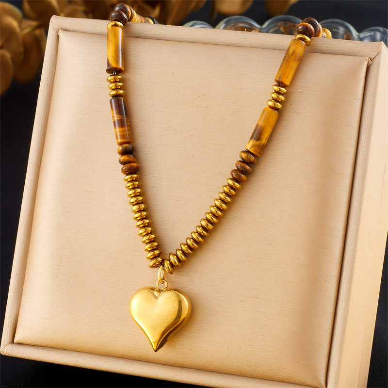 Gold tone necklace with tiger eye beads and a textured round pendant in a gift box