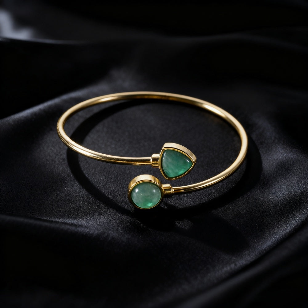 Gold-tone open cuff bracelet with two green aventurine stones on black fabric