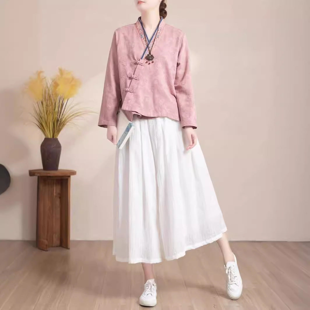 Woman wearing a pink embroidered long sleeve cotton shirt with frog buttons