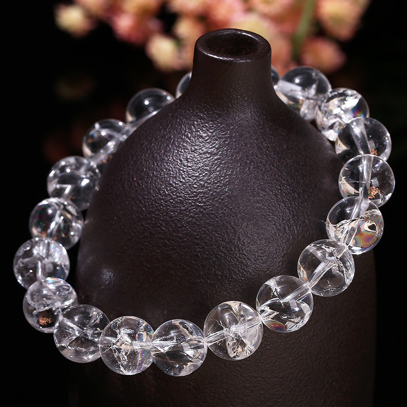 Close up of a clear crystal beaded bracelet on a dark stand