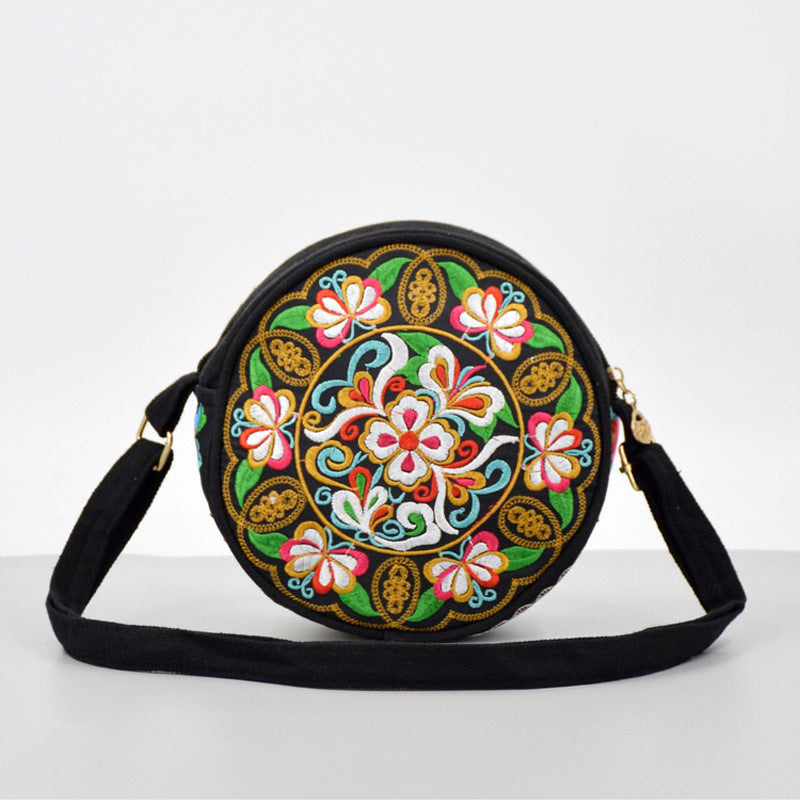 Round black canvas crossbody bag with colorful floral embroidery