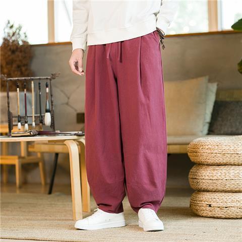 Man wearing burgundy wide-leg harem pants with a drawstring waist