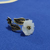 Close up of an adjustable ring with a white jade flower and bronze leaves