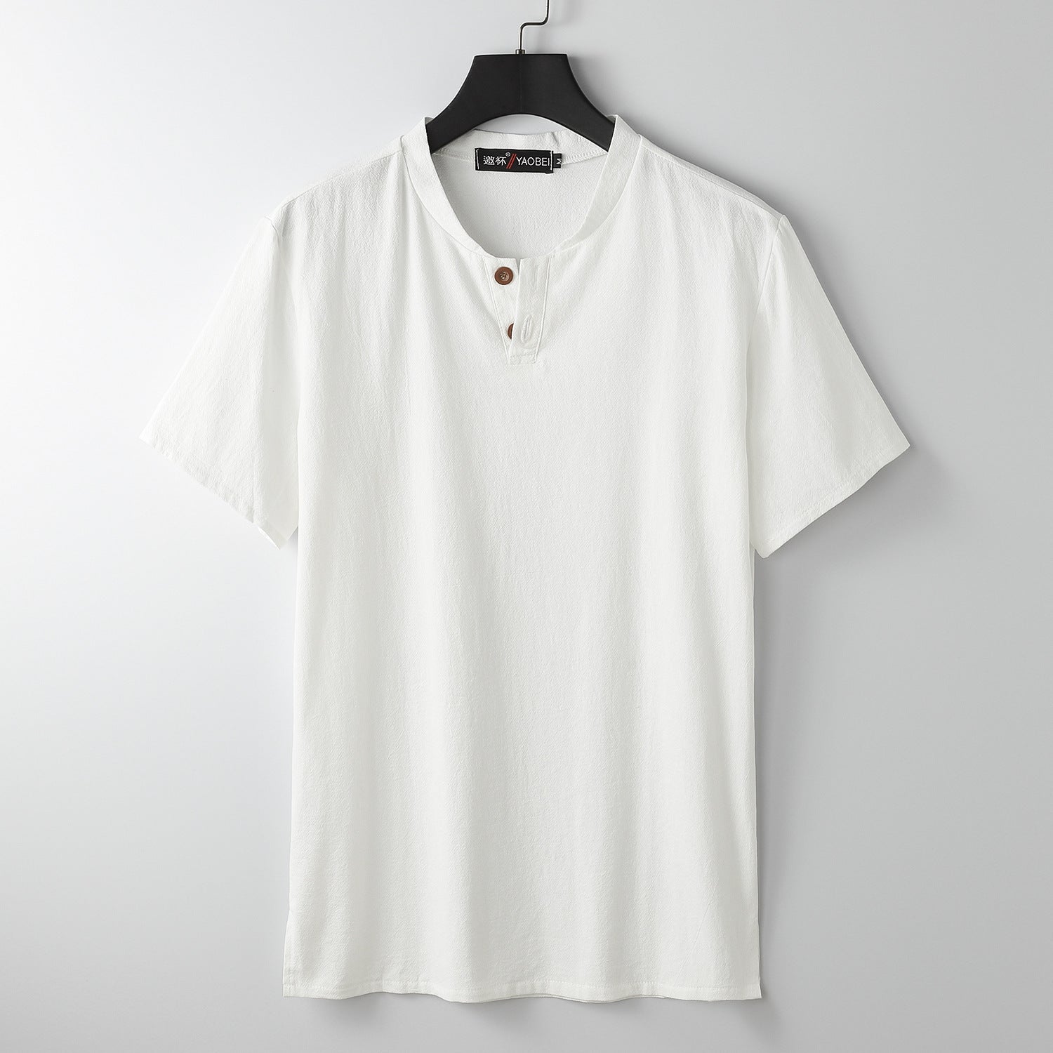 White men's short sleeve henley shirt hanging on a hanger
