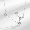 Close up view of a silver necklace with a constellation pendant design