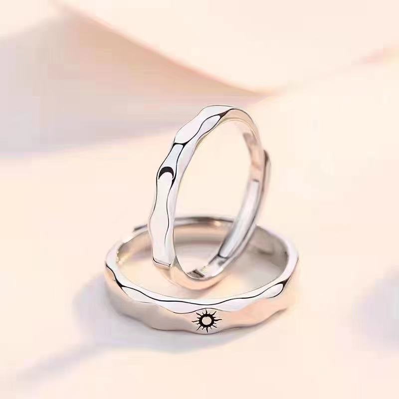 Two silver-tone adjustable rings stacked, one with a sun design and one with a moon design