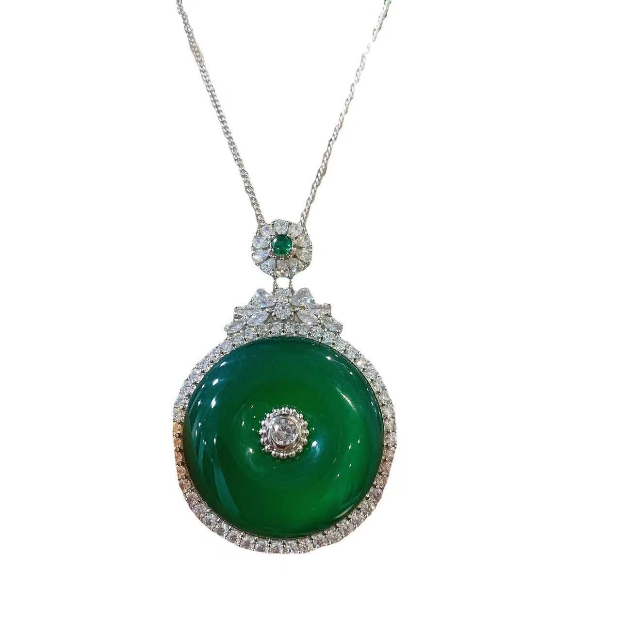 Green chalcedony peace buckle pendant held in hand showing silver-tone setting details