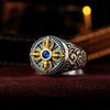 Close up of a copper ring with a gold cross and blue stone center