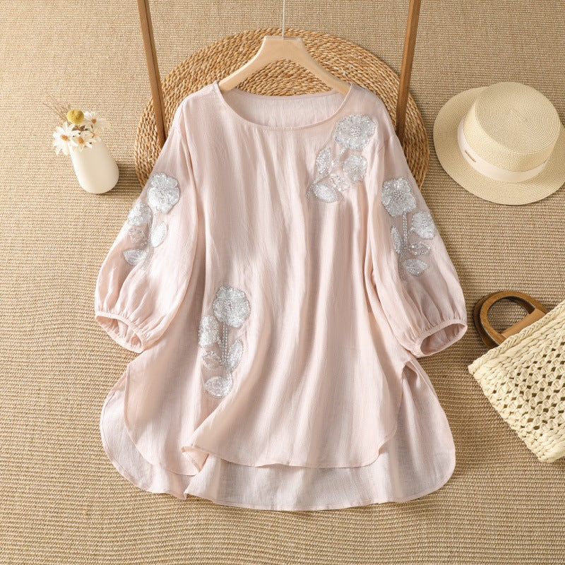 Front view of a loose fitting women's top with floral embroidery and sequin details on the sleeves