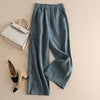 Flat lay of light beige wide leg pants with side pockets next to a handbag
